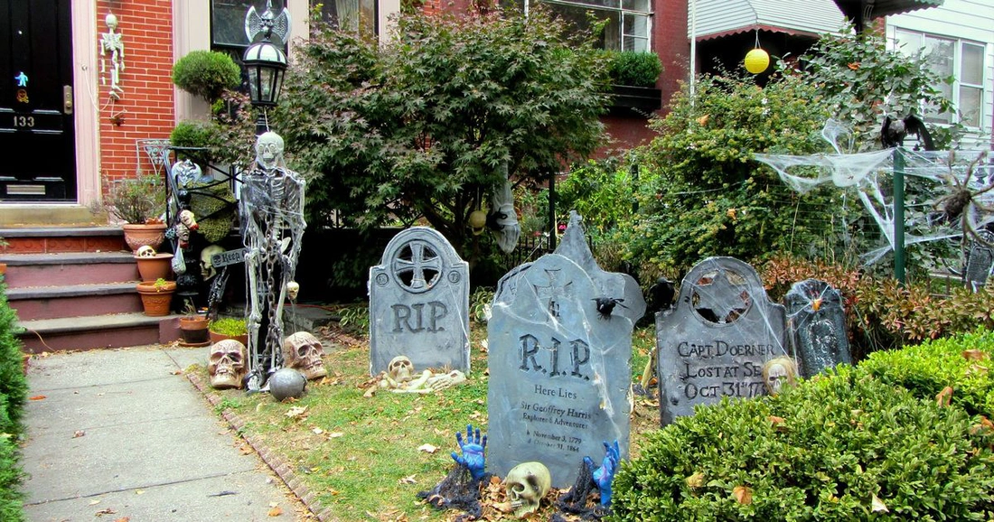Скелет и надгробие в саду на Хеллоуин