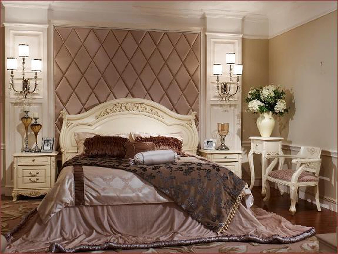 Большая, роскошная кровать с декоративным изголовьем, светлые тона в отделке и обивке мебели.