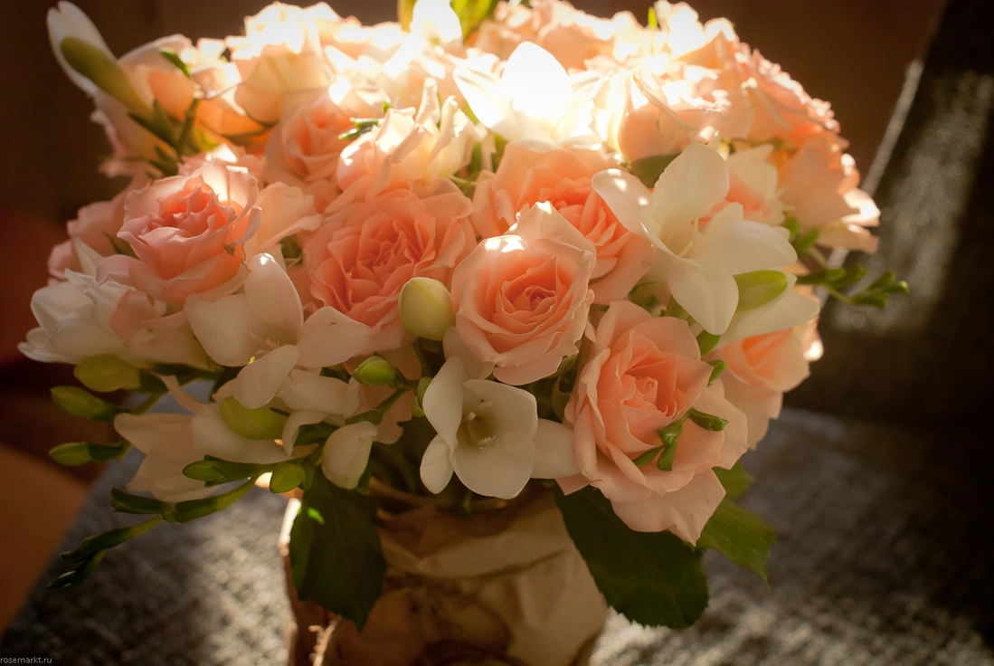 Букет из кустовой розы розового оттенка и белоснежной фрезии в необычной вазе.