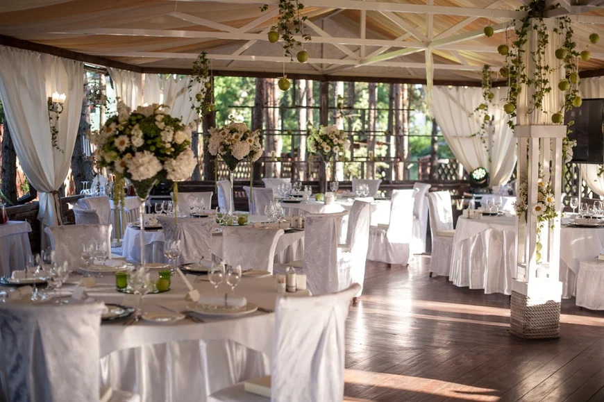 Цветочные композиции на столы гостей могут быть со свечами в вазах на длинных ножках в стиле "мартини"