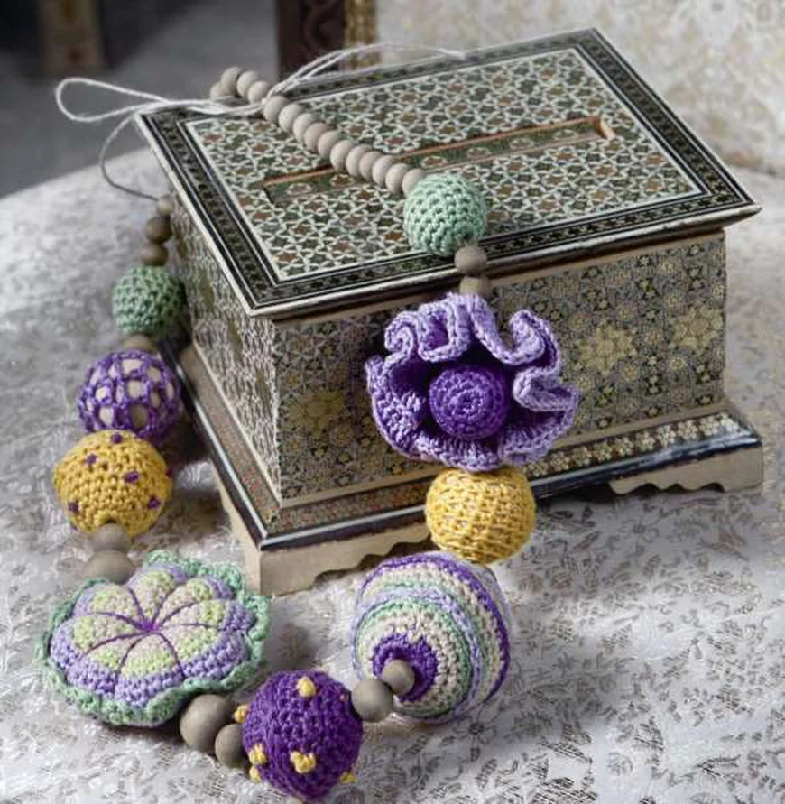 Вязаными гирляндами можно украсить любой предмет мебели, подвесить на стены или использовать , как подхваты для портьер.